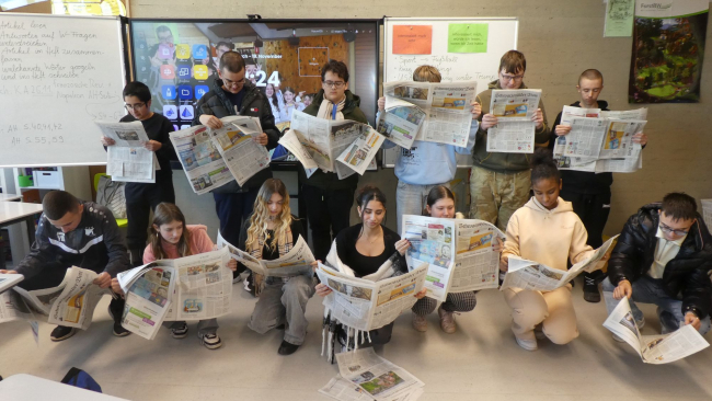 Die Kinder der Klasse 8 lesen ihre Zeitungen.