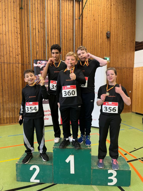 Die erfolgreichen Läufer mit ihren Medaillen auf dem Treppchen.